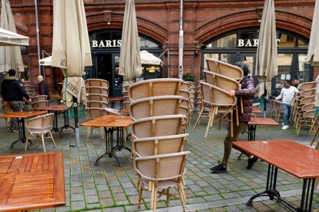 A cafe with chairs being set up outside 