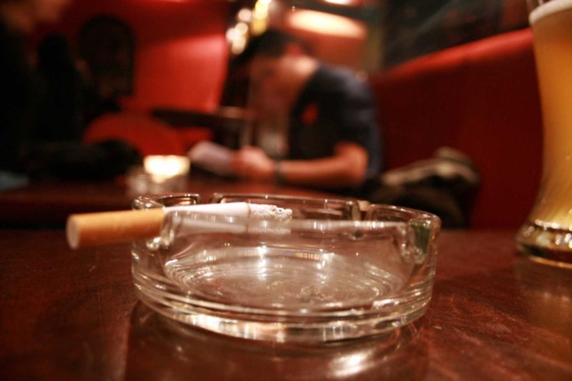 A cigarette burns down in an ashtray which sits inside a bar in Vienna. Photo: AFP