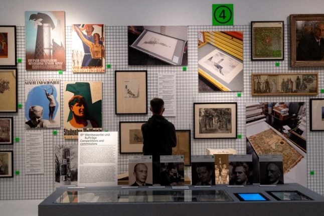 Visitors explore art works at an exhibition titled "Vienna Falls in Line. The Politics of Art under National Socialism" showing Nazi artifacts at the city's "Vienna Museum" in Vienna, Austria,