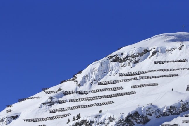Snow and avalanche protection fences seen on a clear day on mountains surrounding Lech am Arlberg, western Austria